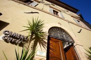 A building with a sign reading "GAMER GARI" and a wooden door. - Camere Carli (Assisi)