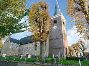 A historic church with a tall steeple and a clock tower. - Home With Vinyls, Bikes and Waterways (Easterlittens)