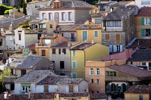 A densely packed urban area with closely built multi-story buildings, featuring various architectural styles and colors.