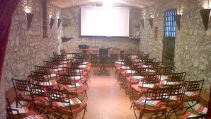 A classroom with stone walls, wooden chairs, and a projector screen. - Villa Life in Vicchio; the Tuskan way (Vicchio)