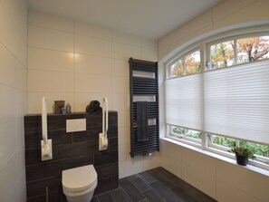 Un bagno moderno con il water, un portasciuga e un termosifone.