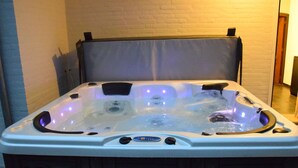 A hot tub with a control panel, a headrest, and a wooden base. - Spacious Villa Near Arcen in a Wooded Area (Arcen)