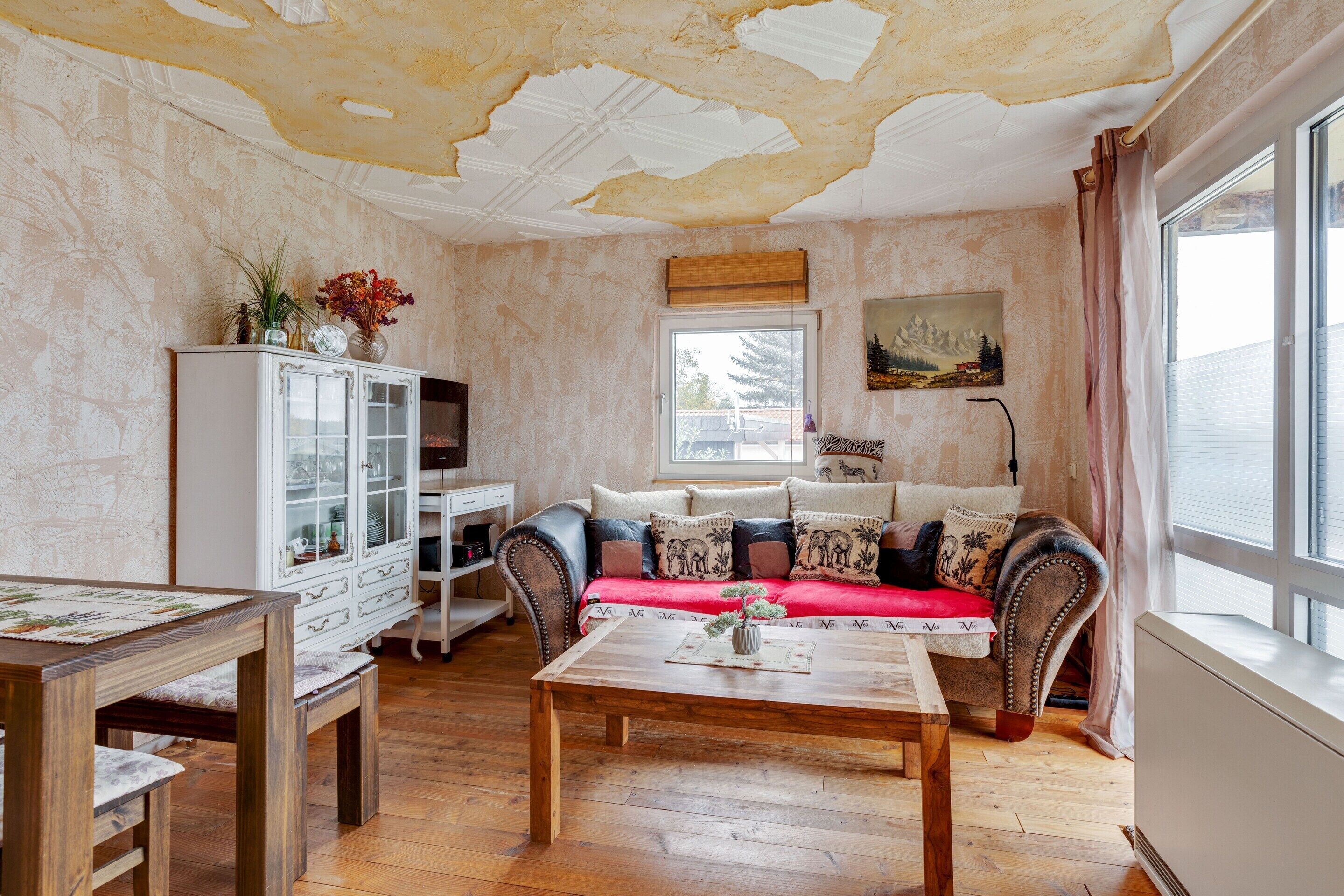 A living room with a sofa, wooden coffee table, white cabinet, and a painting on the wall.