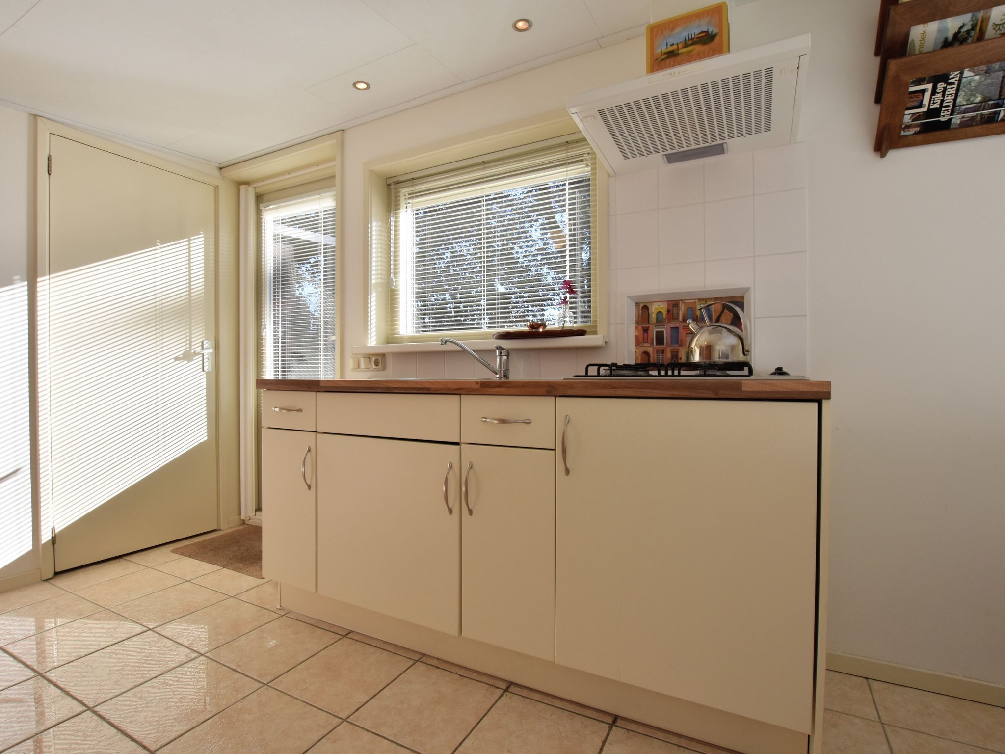 A kitchen with a stove, sink, and cabinets.