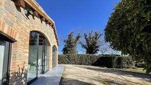 Un edificio de piedra con grandes puertas de cristal y un camino de grava.