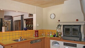 Eine Küche mit Spüle, Kaffeemaschine, Mikrowelle und einer Uhr an der Wand.
