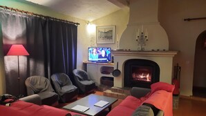 Ein Wohnzimmer mit Kamin, Fernseher und einer Couch.