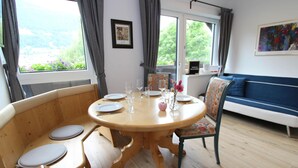 A dining area with a wooden table, chairs, and a sofa. - Apartment Salzburg Near Speiereck Lift (Sankt Michael im Lungau)