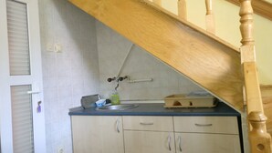 A kitchen with a wooden staircase, a sink, cabinets, and a window with blinds. - Enjoy the nature on Zlatibor (Zlatibor)