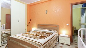 Une chambre à coucher avec un lit, des tables de chevet, une armoire et un miroir.