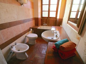 A bathroom with a toilet, bidet, and bathtub. There are towels on the floor. - Cottage With Lake Views (Magione)