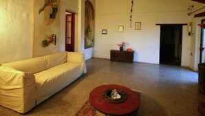 Ein geräumiges Wohnzimmer mit einem gestreiften Sofa, einem roten Couchtisch und einem Gemälde an der Wand.