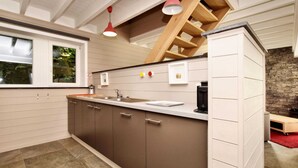 A modern kitchen with a central island, a built-in stove, and pendant lighting. - Stylish Holiday Home in Houffalize With Sauna, Patio, Garden (Houffalize)