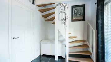 Eine Treppe mit Holzsitzen und weißen Geländern, die zu einer oberen Etage führt.