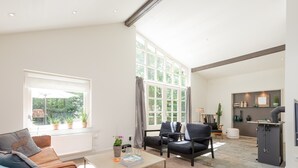 A modern living room with a sofa, armchairs, a coffee table, and a fireplace. - Beautiful Holiday Home With Sauna (Heino)
