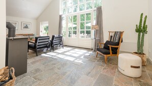 A spacious room with a dining area, a large window, and a cactus plant. - Beautiful Holiday Home With Sauna (Heino)