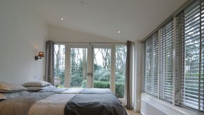 A bedroom with two beds, a view of the outdoors, and a window with blinds. - Beautiful Holiday Home With Sauna (Heino)