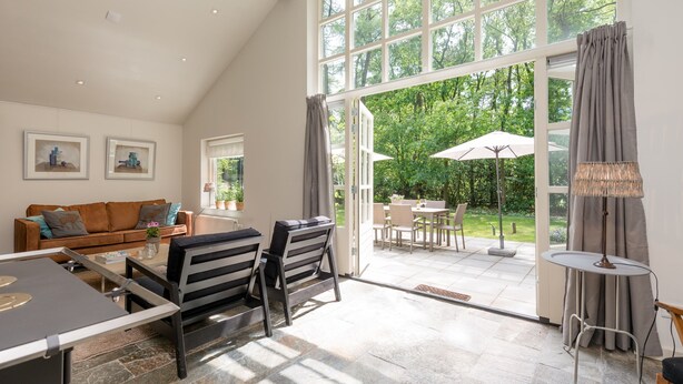 A spacious living area with a large window, a dining table, and a sofa. - Beautiful Holiday Home With Sauna (Heino)