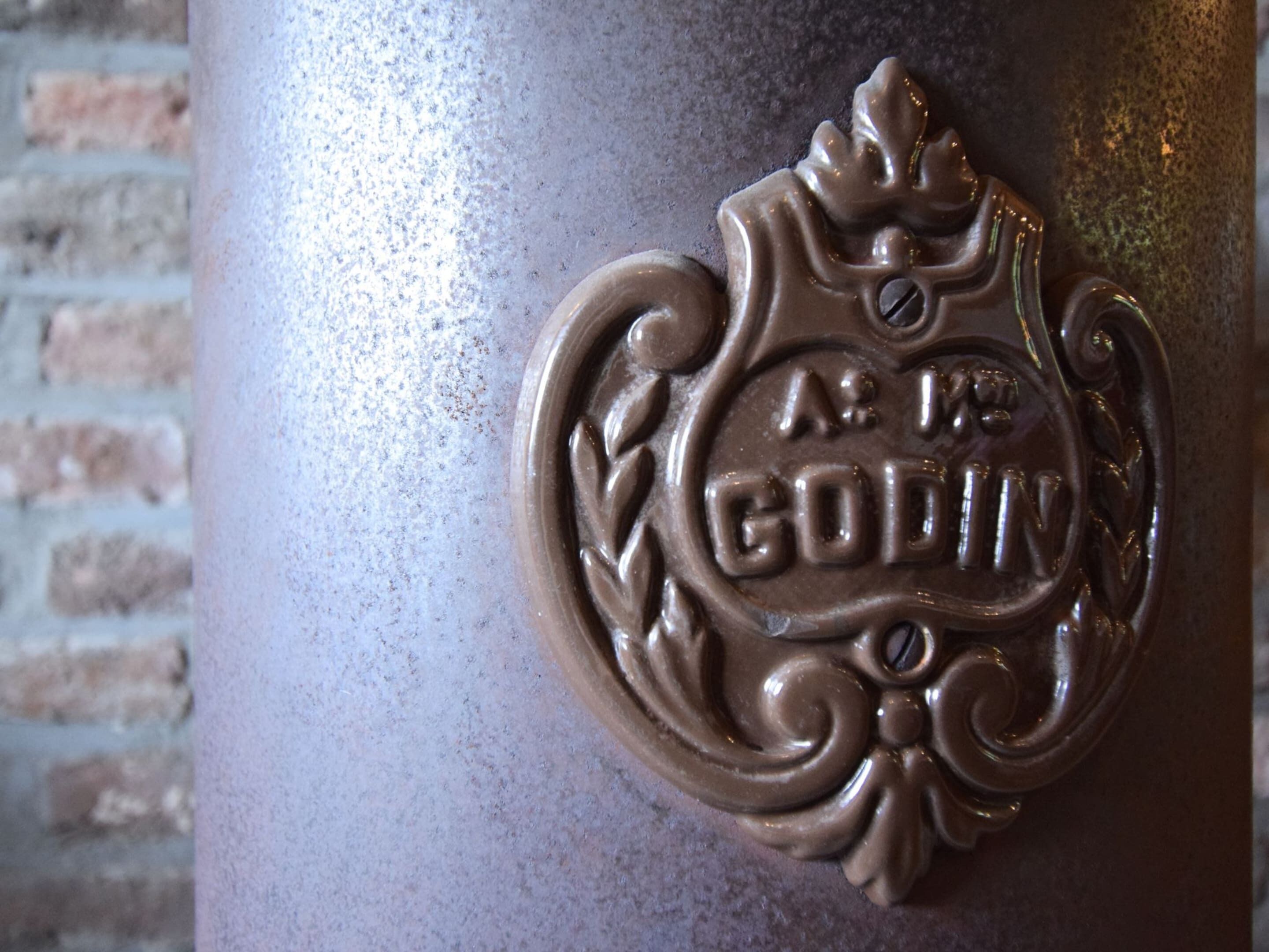 Un emblema metálico con relieve que tiene la inscripción 