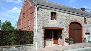 A stone building with a large wooden door and a brick chimney. - Cozy Family Stay in Durbuy (Durbuy)