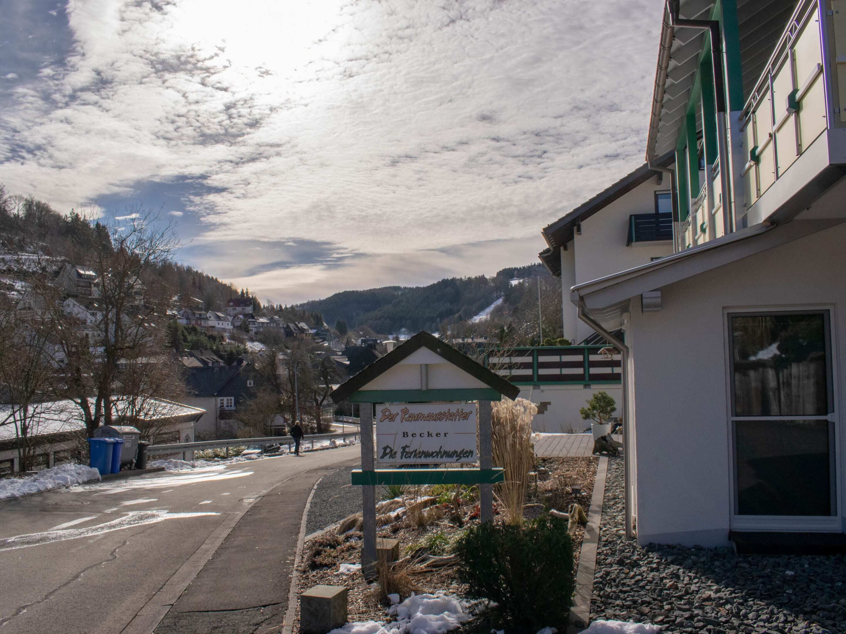 A building with a sign indicating a restaurant named "Der Raumeisler" in a snowy, hilly area.