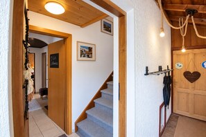 A staircase leading to a room with a wooden door, a framed picture on the wall, and a sign that reads 'Willkommen' (Welcome). - Cozy Apartment in Kitzbuhel near Ski Area (Kitzbuhel)