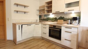 Eine moderne Küche mit Holzausstattung, einem Einbauofen und einer Kaffeemaschine.