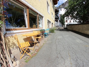 A narrow street with a yellow table and chairs outside a building with large windows. - Modern Apartment in Fieberbrunn With Terrace (Fieberbrunn)