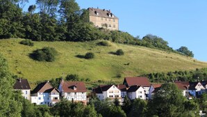 A hilltop house with a traditional design, surrounded by a residential area with similar houses.