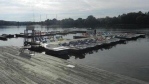 A marina with several boats docked at wooden piers.