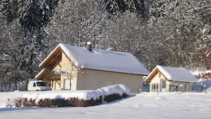 A snow-covered cabin with a vehicle parked in front, surrounded by trees. - Holiday Home in Vosges With Garden and BBQ (Haut-du-Them-Château-Lambert)