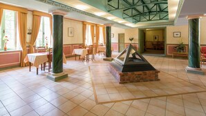 A spacious lobby with high ceilings, a central fireplace, and multiple seating areas. - Apartment in Rhone Alpes Near Ski Slopes (Montbrun-les-Bains)