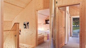 A wooden interior with a bed, a TV, and a large pipe. - Spacious Holiday Home in Styria near Kreischberg Ski Area (Sankt Georgen am Kreischberg)