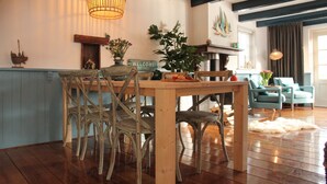 A wooden dining table with wicker chairs, a 'WELCOME!' sign, and a potted plant. - Holiday Home in Hindeloopen by Lake (Hindeloopen)