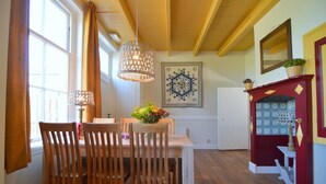 Uma área de refeições com cadeiras de madeira, uma mesa e um lustre.