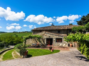 A stone house with a tiled roof, a paved driveway, and a garden with potted plants. - Holiday Home in Chianti With Pool (Greve in Chianti)