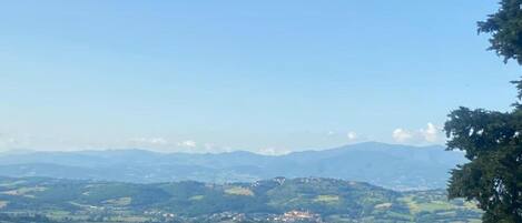 A panoramic view of a hilly landscape with scattered buildings, likely a rural area.