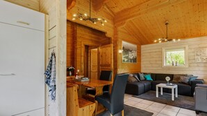 L’intérieur d’un chalet accueillant, avec un coin repas en bois, un canapé et une petite table.