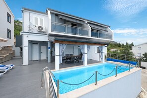 A two-story building with a pool, outdoor seating, and a covered patio area. - Peace & Sun Await in Dalmatia (Starigrad)