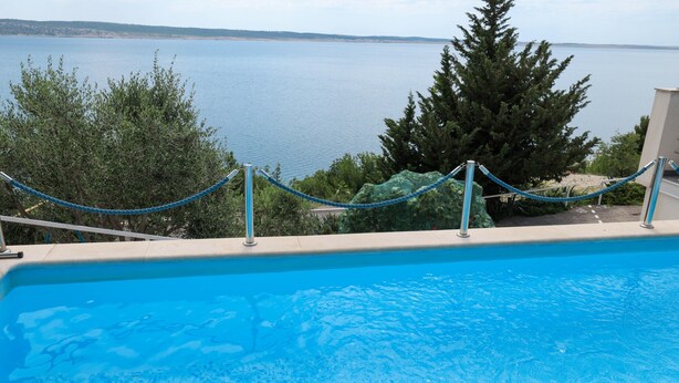 A swimming pool with a view of the sea and trees. - Peace & Sun Await in Dalmatia (Starigrad)