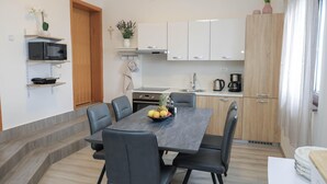 A modern kitchen with white cabinets, a microwave, and a coffee maker. - Peace & Sun Await in Dalmatia (Starigrad)