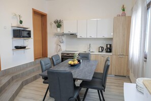 A modern kitchen with white cabinets, a microwave, and a coffee maker. - Peace & Sun Await in Dalmatia (Starigrad)