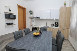 A modern kitchen with white cabinets, a microwave, and a coffee maker. - Peace & Sun Await in Dalmatia (Starigrad)