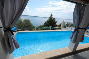 A swimming pool with a view of the sea and trees. - Peace & Sun Await in Dalmatia (Starigrad)