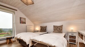A bedroom with two beds, a window with a view, a small stool, and a nightstand with a lamp. - Holiday Home Suitable for Families With Sauna (Houffalize)