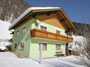 A two-story chalet with a sloped roof, wooden balcony, and multiple windows. - Newly Furnished Appartment at the Mouth of the Poller Valley National Park (Rennweg am Katschberg)