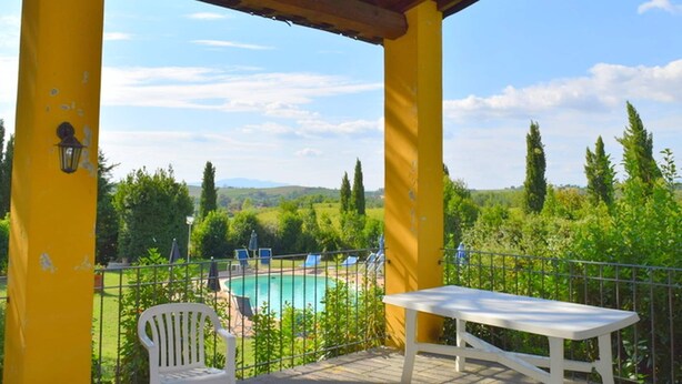 A covered outdoor area with a pool, a white table, and a white chair. - Restful Farmhouse with Pool near Forest in Vinci (Vinci)