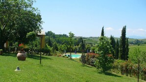 A lush green lawn with a swimming pool, surrounded by trees and a clear sky. - Restful Farmhouse with Pool near Forest in Vinci (Vinci)