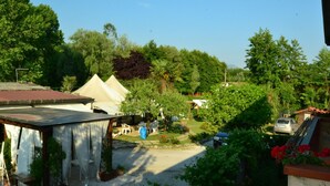 A garden area with a gazebo, a tent, and a car parked nearby. - Belvilla by OYO Serena (Massa)