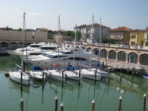 A marina with several yachts docked, surrounded by buildings with arched windows and balconies. - A Serene Stay in Gemmano (Gemmano)